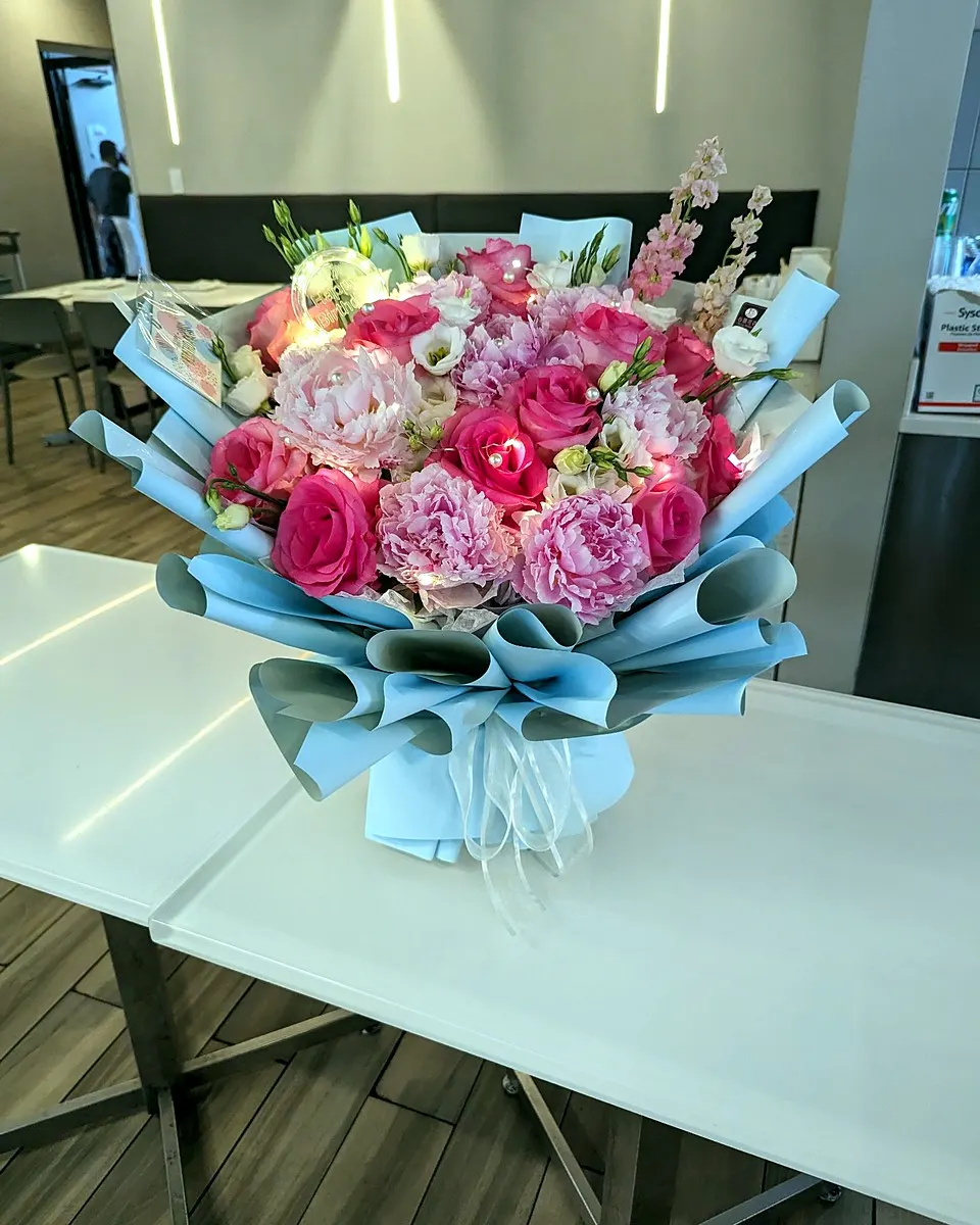 Hand-tied red rose bouquet wrapped in white paper