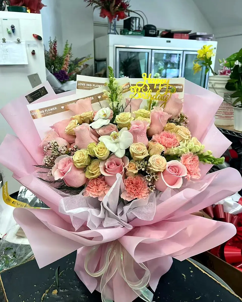 Pink rose bouquet wrapped in soft blue paper
