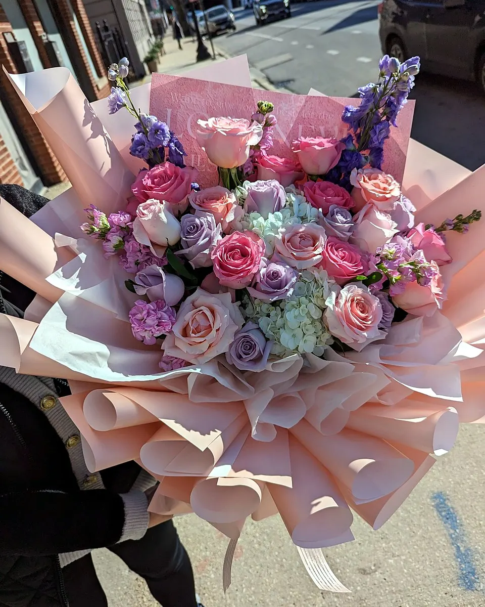Pink bouquet with layered rose blooms and delicate accents