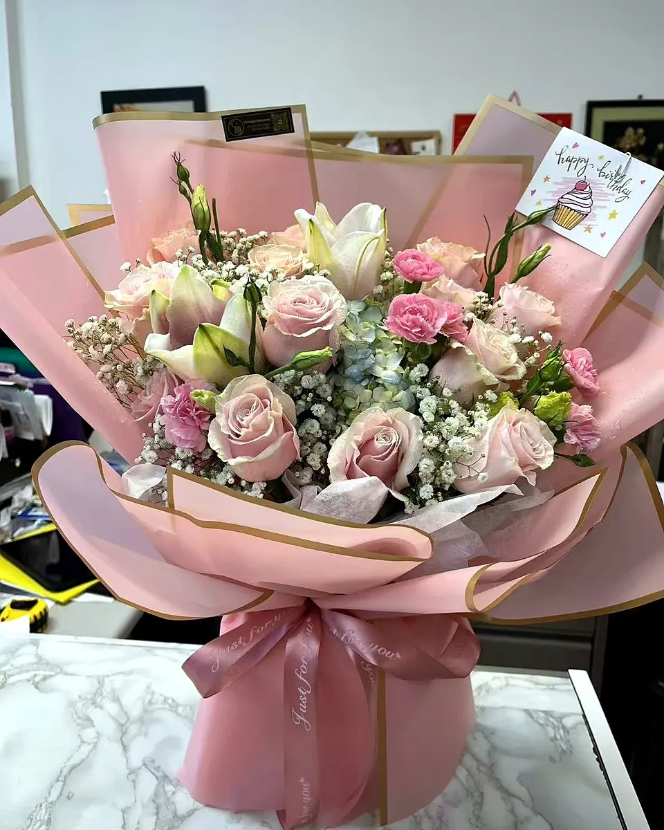 Blush pink gift bouquet with roses and soft textured blooms