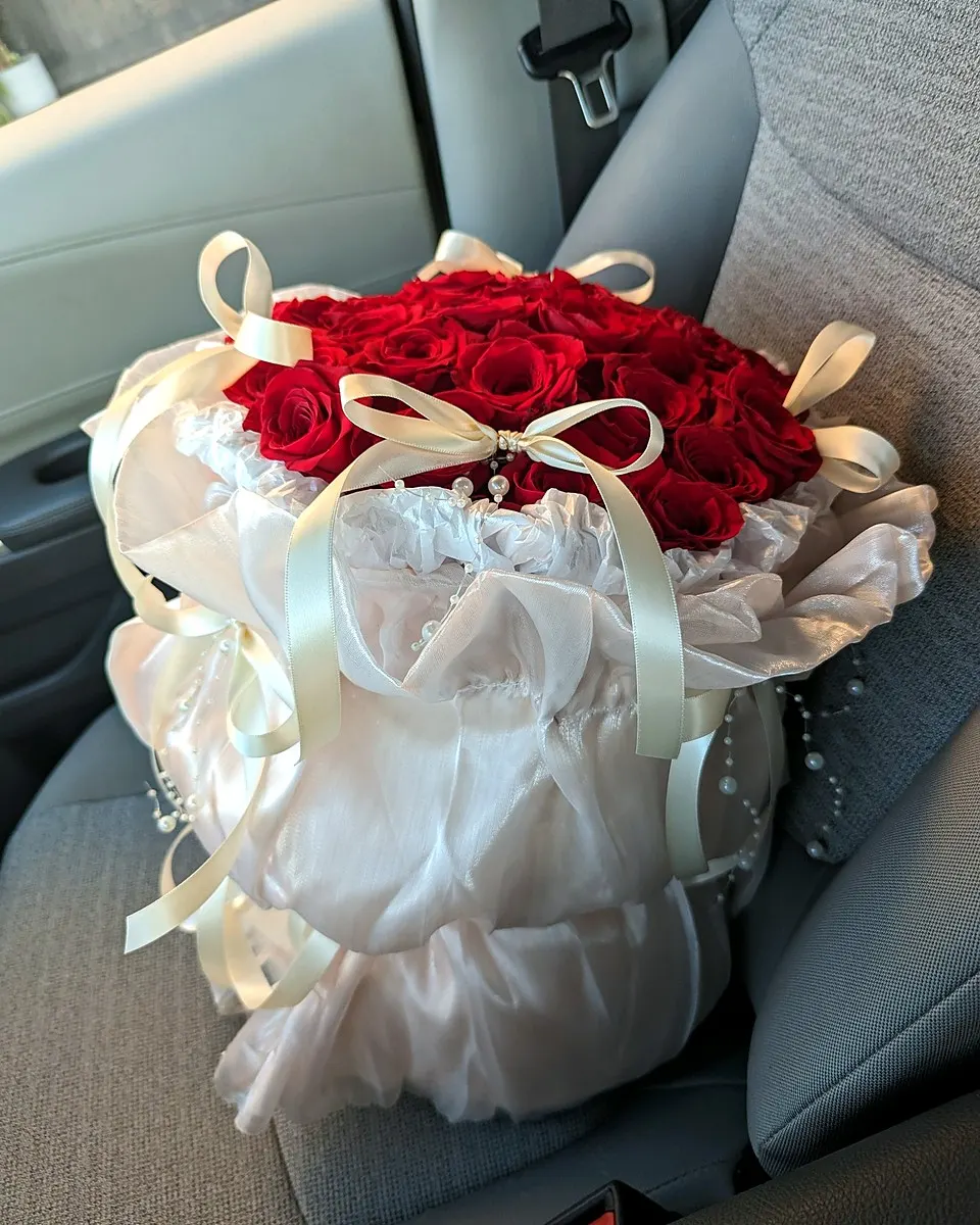 Coral pink bouquet with peonies, roses, carnations, and white flowers