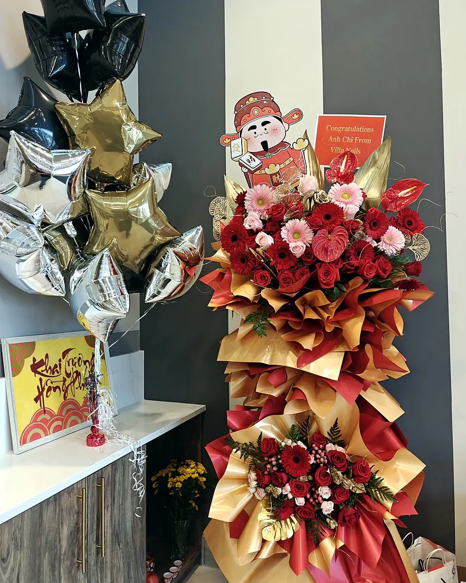 Red and burgundy grand opening flower stand with a ribbon bow