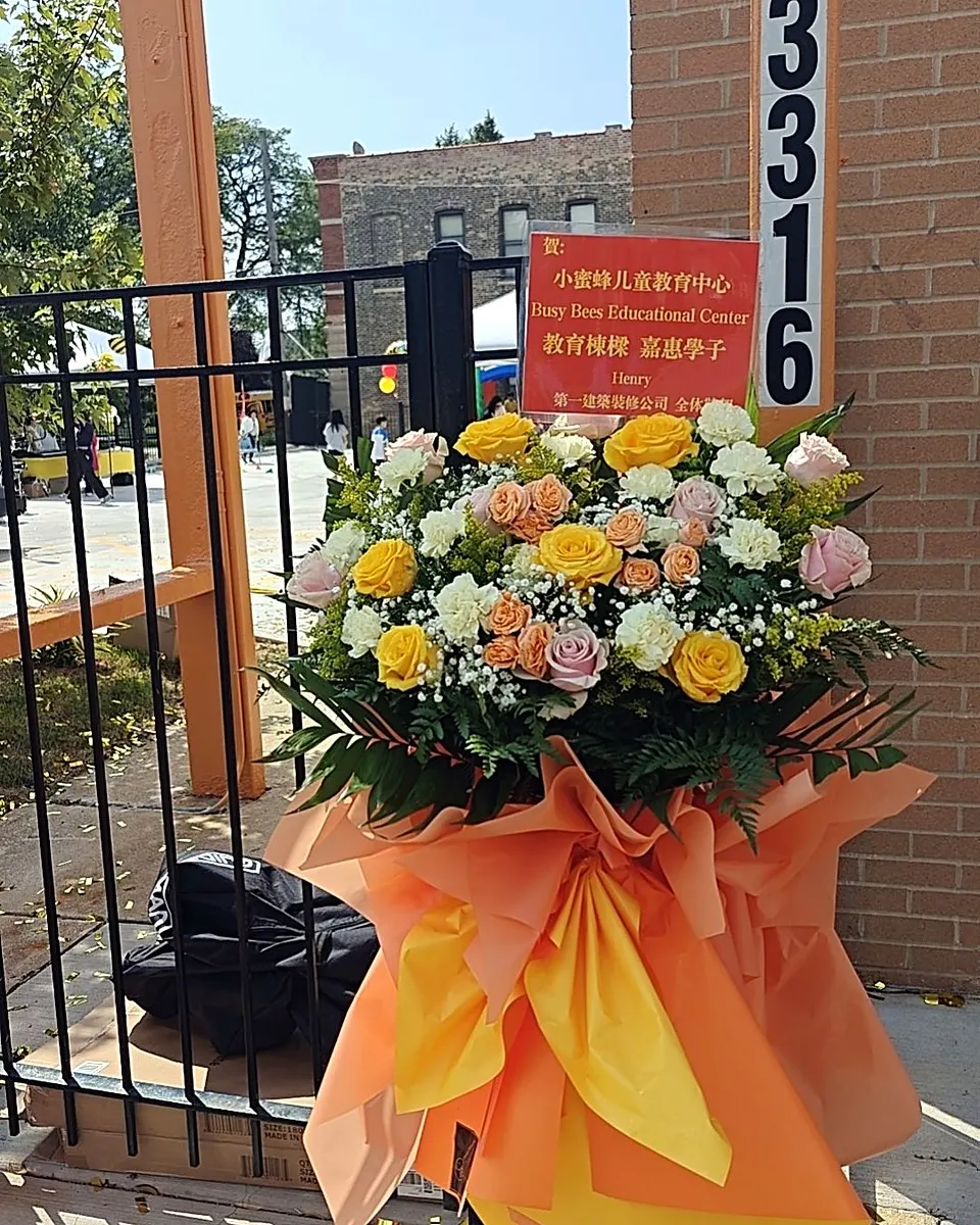Yellow and orange grand opening flower arrangement on a standing frame
