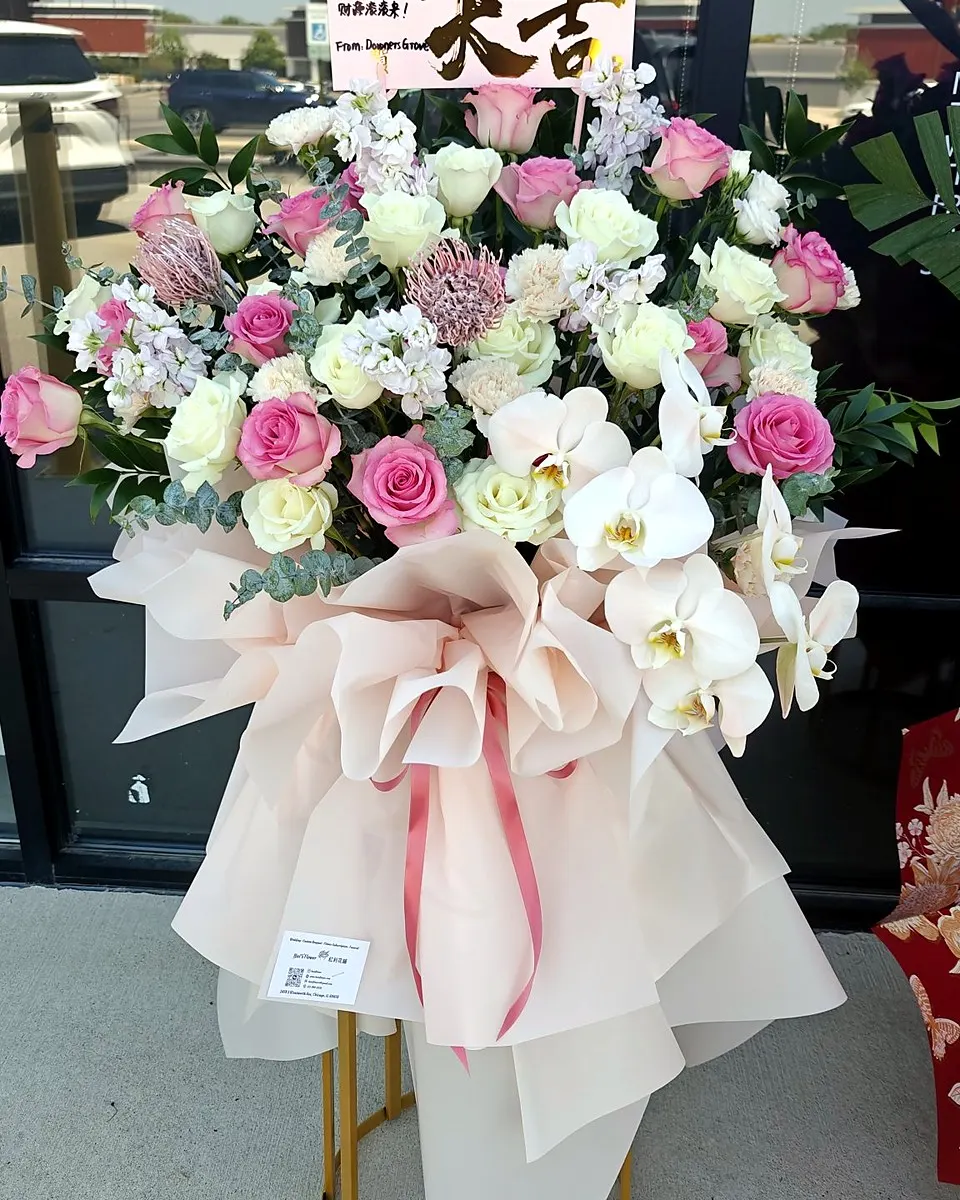 Red and pink grand opening flower stand with layered blooms and greenery