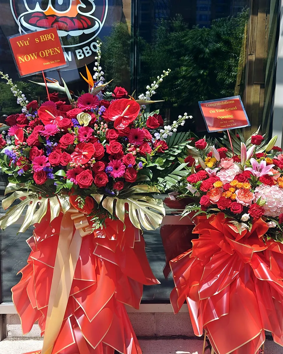 Pink and red grand opening flower arrangement on a standing frame