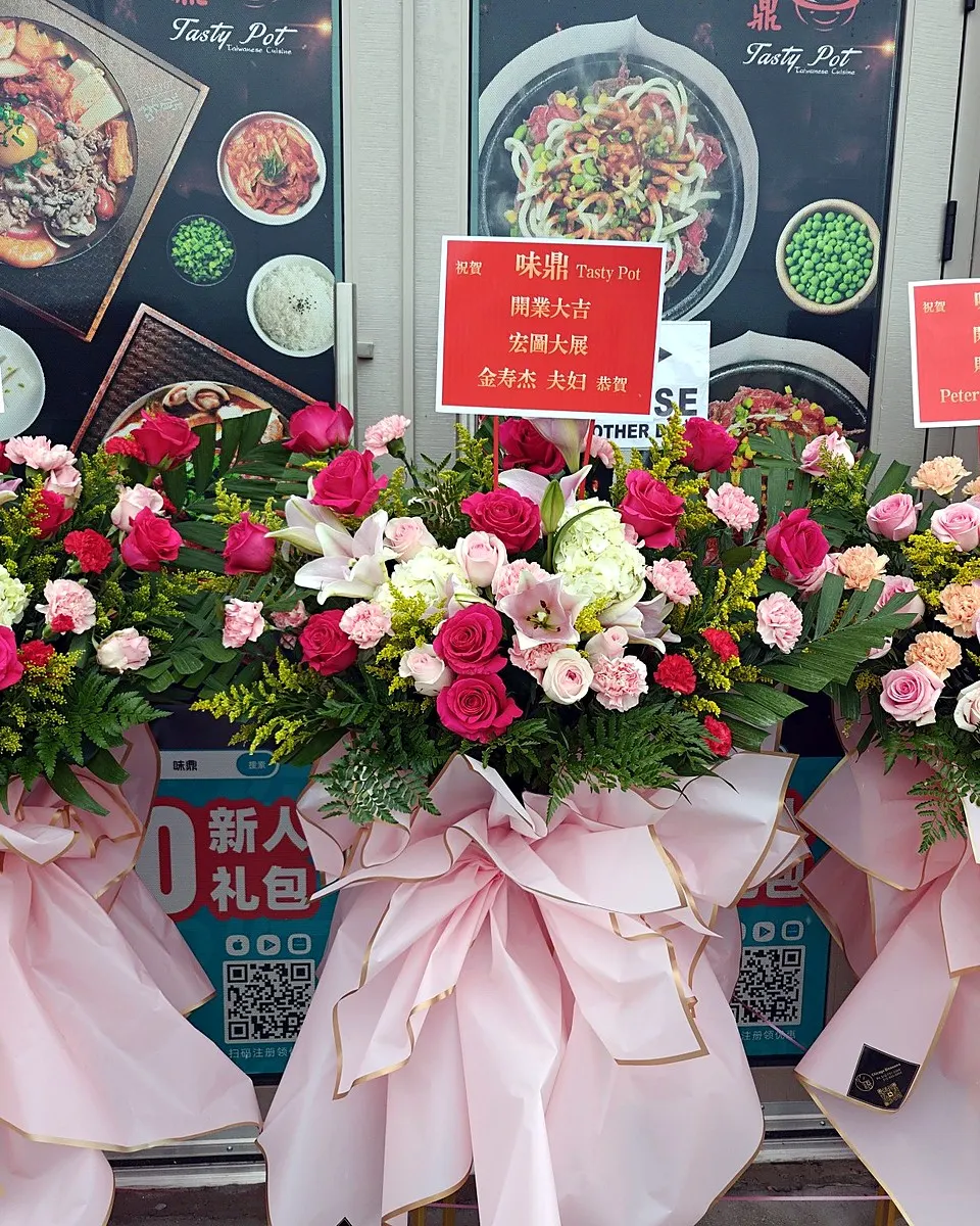 Three pink grand opening flower stands with roses, lilies, hydrangeas, and carnations