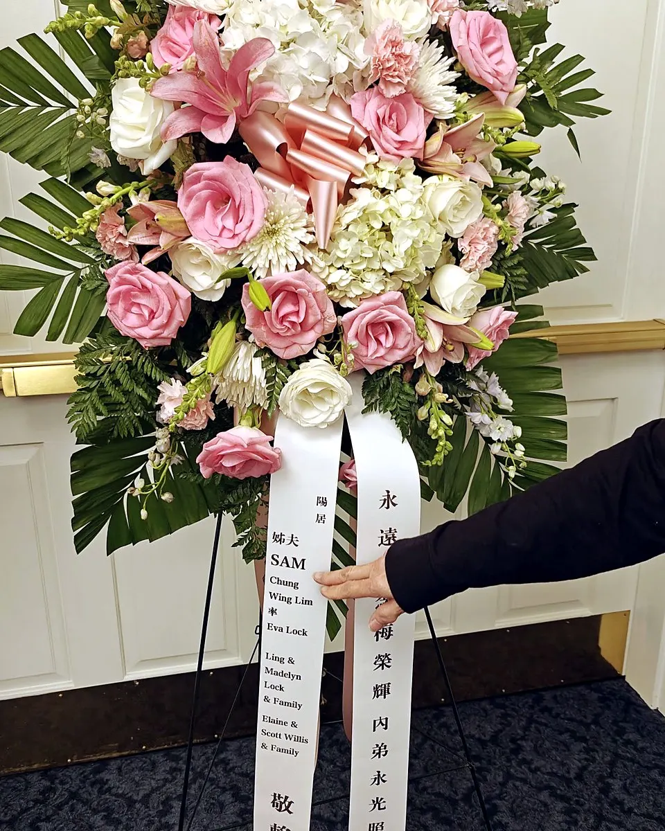 Pink and white standing funeral spray with roses, lilies, hydrangeas, and chrysanthemums