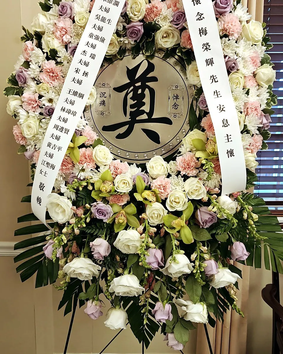 Pastel pink, lavender, and white memorial wreath with cascading flowers