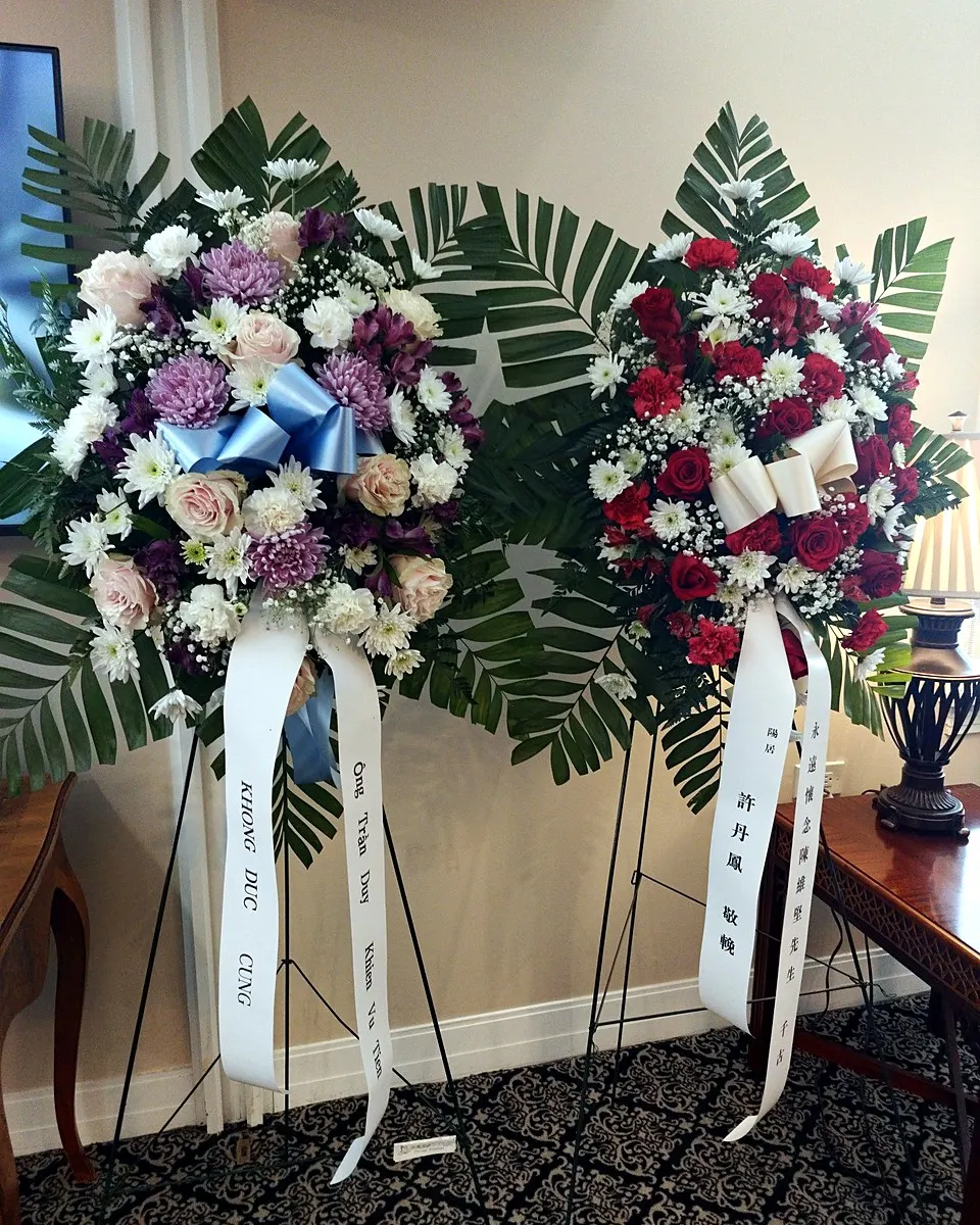 Purple and white standing funeral spray with roses and lilies