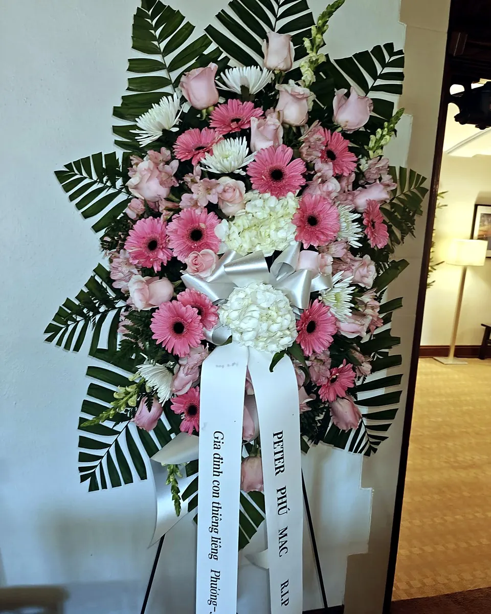 Pink and white standing funeral spray with gerbera daisies, roses, and hydrangeas
