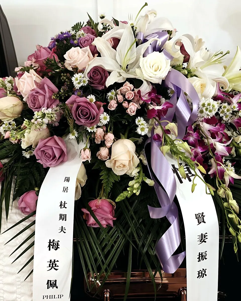 Lavender, pink, and white casket spray with roses, lilies, and orchids