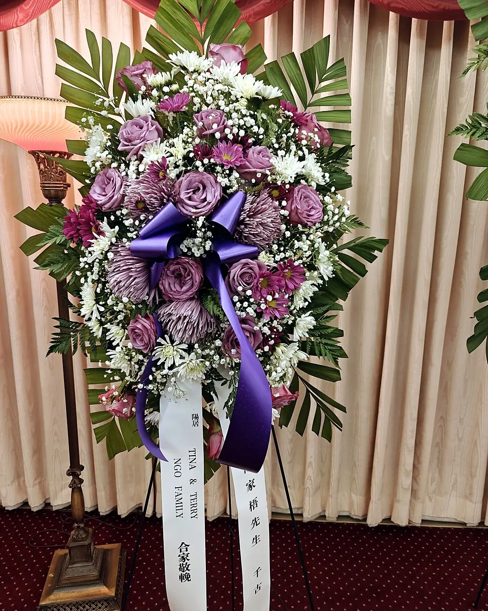 Lavender and white standing funeral spray with roses and chrysanthemums
