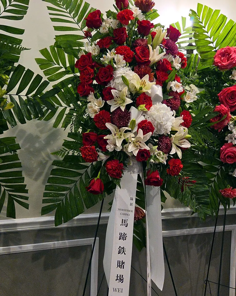Red and white standing sympathy arrangement with roses and lilies