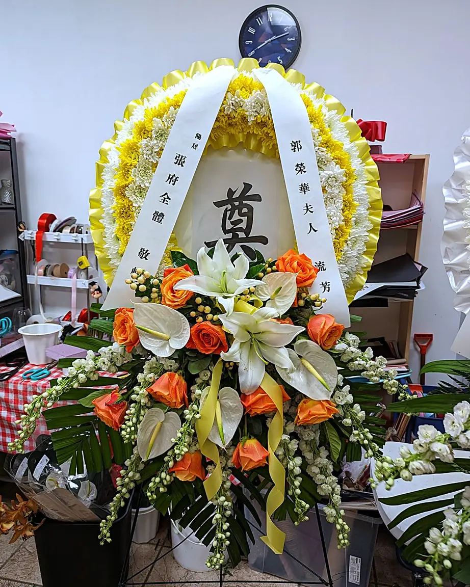 Yellow and white chrysanthemum funeral wreath with orange roses and white anthuriums